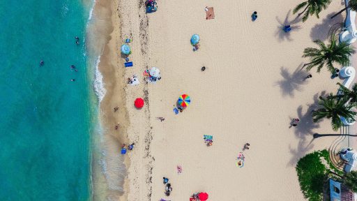 Luftaufnahme von einem Strand mit Sonnenschirmen